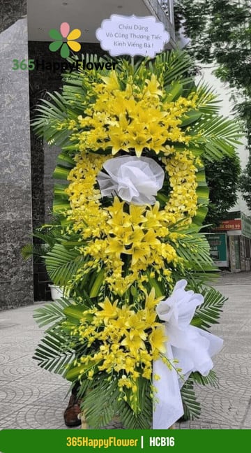 Kệ hoa chia buồn dáng oval hoa ly vàng và lan dendro HCB16